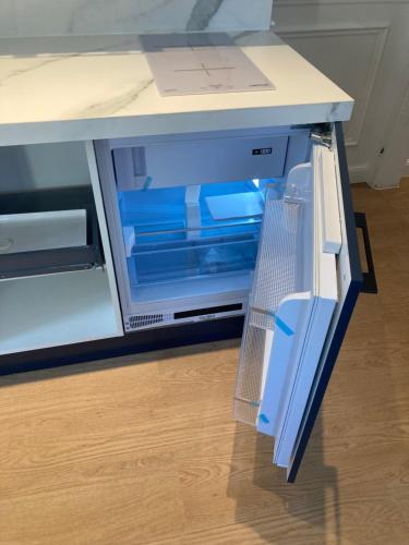 un réfrigérateur vide avec sa porte ouverte sur un comptoir dans l'établissement Splendid appartement, à Rouen