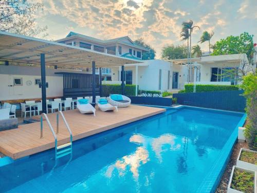 a swimming pool in a backyard with a house at BBG Beachfront poolvilla 5BR close to Huahin city in Cha Am