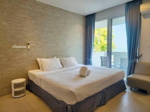 a bedroom with a large bed and a balcony at BBG Beachfront poolvilla 5BR close to Huahin city in Cha Am