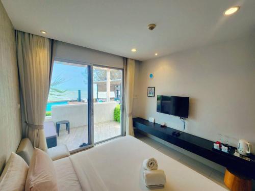 a bedroom with a large bed and a large window at BBG Beachfront poolvilla 5BR close to Huahin city in Cha Am
