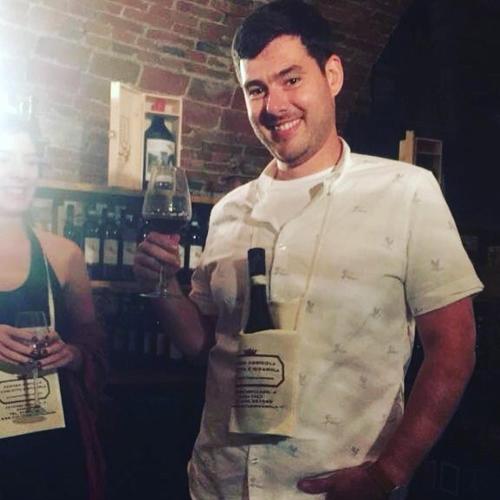 a man holding a bottle of wine and a glass at Castello di Grillano Guest House in Ovada