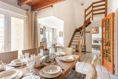 une salle à manger avec une table et des chaises en bois dans l'établissement Duplex Appartement 300m de la mer, à Fréjus