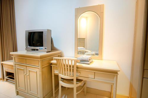 a room with a desk with a tv and a mirror at Hotel Permata Malioboro in Yogyakarta