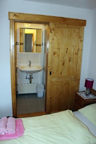 a bedroom with a bathroom with a sink and a bed at Appartements Schmidsendl in Lofer