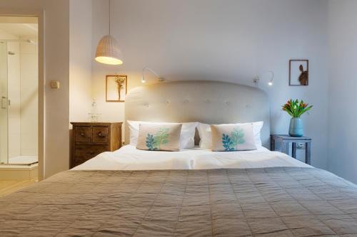 a bedroom with a large bed with white sheets and pillows at homie hotel oechsle & brix in Sommerhausen