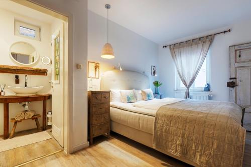 a bedroom with a large bed and a sink at homie hotel oechsle & brix in Sommerhausen