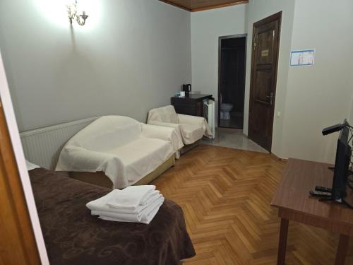 a room with two beds and a wooden floor at Hotel Cattaleya in Batumi
