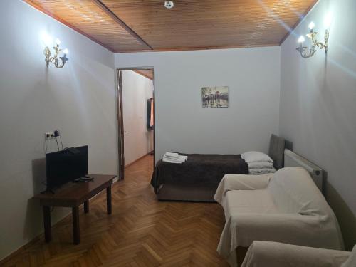 a living room with a couch and a bed at Hotel Cattaleya in Batumi