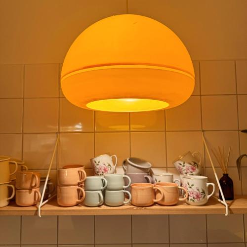 a light above a shelf with pots and mugs at Farma Kalhov in Kalhov