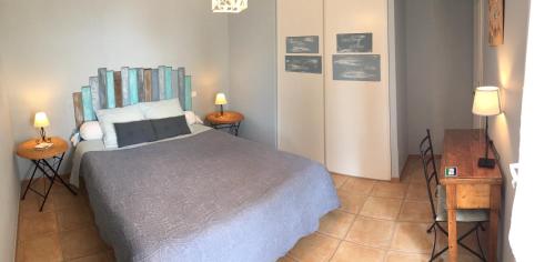 une chambre avec un grand lit et deux lampes dans l'établissement Gites Mas Du Cadranier, à Villeneuve