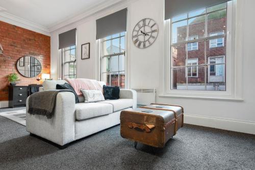 a living room with a couch and a suitcase at WhiskAwayStays Foregate Studio No 1 in Worcester