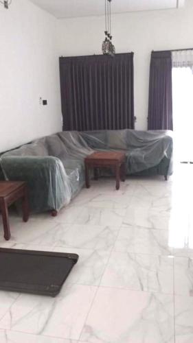 a living room with a couch and a table at Rumah 5KT Sby Brt dkt Kidzania in Surabaya