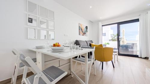 eine weiße Küche mit einem weißen Tisch und Stühlen in der Unterkunft PANORAMIC relax apartment in Finestrat