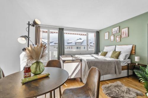 a bedroom with a bed and a table and chairs at Studio mit Bergblick Titlis, Luzern, Pilatus, See in Engelberg