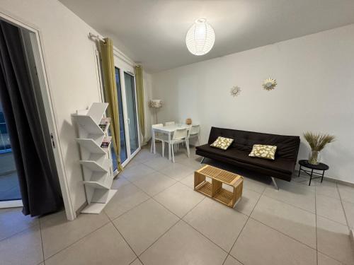 un salon avec un canapé noir et une table dans l'établissement MountainLake Gateway, à Annecy