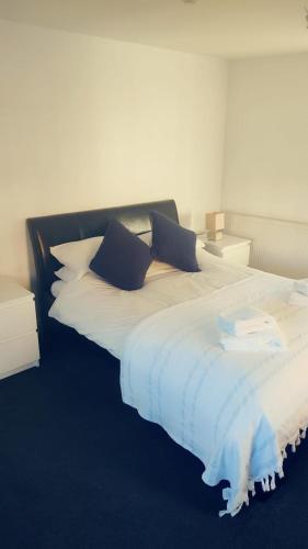 a large bed with blue and white sheets and pillows at The Black Lion in Bridlington