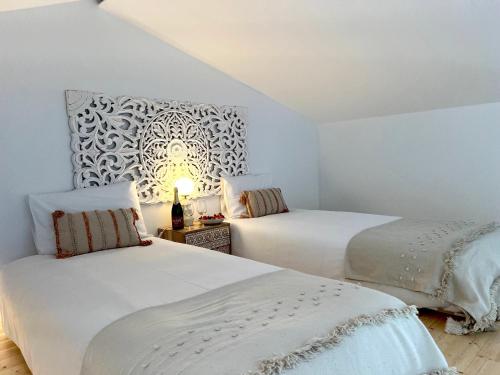 a bedroom with two beds and a wall mural at Casa Amoreira in Carrapateira