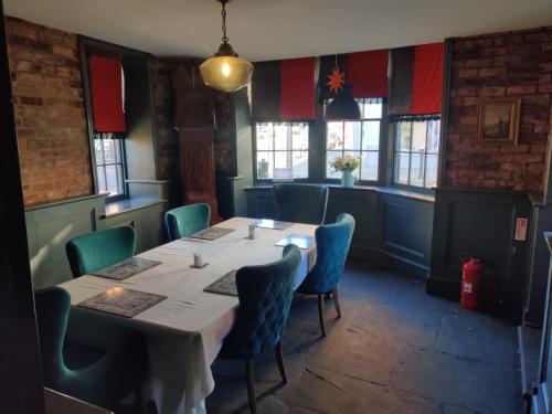 a dining room with a table and blue chairs at The Black Lion in Bridlington