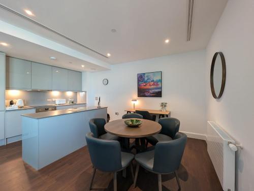 a kitchen and dining room with a table and chairs at Charles Hope Canary Wharf South Quay in London
