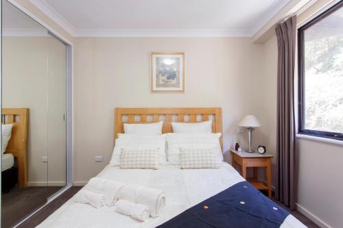 a bedroom with a large bed and a window at Resort-style living in Perth CBD - 2X2 Apt in Perth