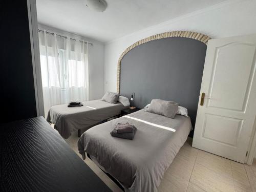 a bedroom with two beds and a window at Aires de Regla, Apartamentos Living Sur in Chipiona
