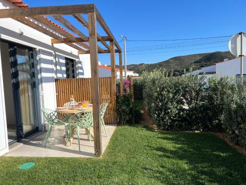 a small patio with a table and a wooden pergola at Casa Amoreira in Carrapateira