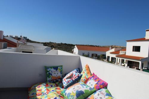 a group of pillows sitting on top of a balcony at Casa Amoreira in Carrapateira