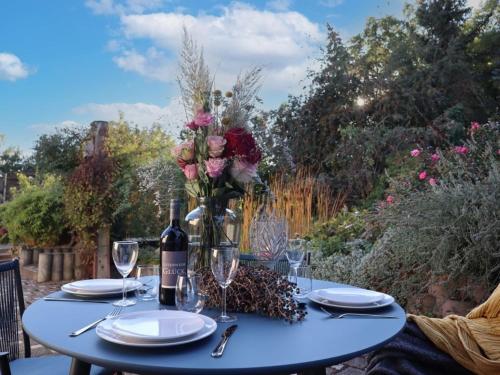 a table with a bottle of wine and a vase of flowers at Naturferienhaus an der Burg für bis zu 8 Personen in Groß Rosenburg