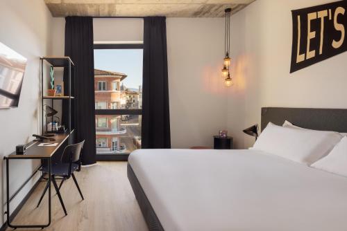 ein Schlafzimmer mit einem Bett, einem Schreibtisch und einem Fenster in der Unterkunft The Social Hub Florence Belfiore in Florenz