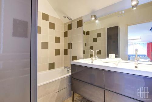 a bathroom with a sink and a tub and a mirror at Le Duplex - loft - 4 voyageurs in La Riche
