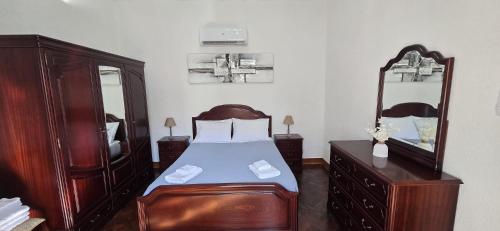 una camera da letto con un letto, un comò e uno specchio di Fifty's House 2 By Sam Houses a Ribeira Brava