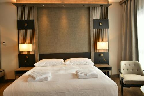 a bedroom with a large white bed with two pillows at Doubletree By Hilton Kars Sarikamis in Sarıkamıs