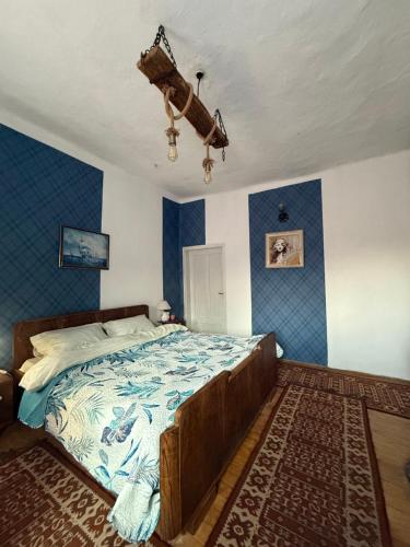 a bedroom with a large bed with blue walls at Къща За Гости Двата Ореха in Protopopintsi