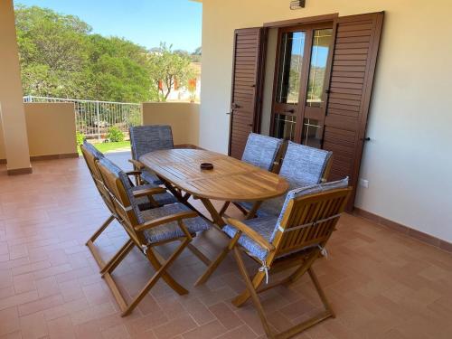 a wooden table and chairs on a patio at Bellavista in Castiadas