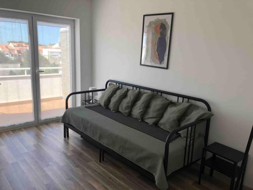 a bed sitting in a room with a window at Appartement 3Z - Centre de Esposende avec vue sur la ville in Esposende