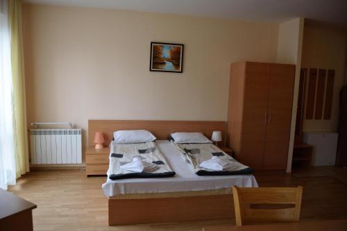 a bedroom with two beds and a cabinet at Persey Flora Apartments in Borovets