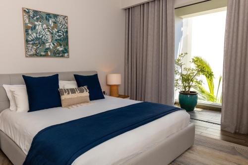 a bedroom with a large bed and a window at Tropical beachfront apartment in Belle Mare