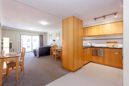 a kitchen and living room with a table and a couch at Resort-style living in Perth CBD - 2X2 Apt in Perth