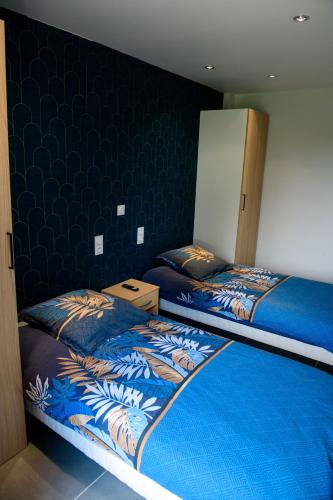 - une chambre avec 2 lits jumeaux aux murs bleus dans l'établissement La bonne adresse, à Sainte-Sigolène