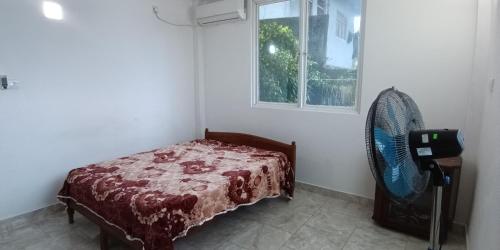 a bedroom with a bed and a window and a fan at Heavenly Retreat in Malabe