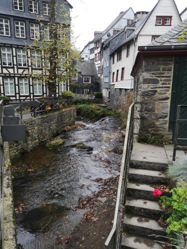 a river in a city with buildings and stairs at Ferienwohnung in Waldrandlage in Nationalpark Schleiden / Eifel in Schleiden