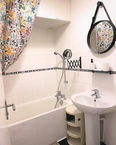 une salle de bain blanche avec un lavabo et une baignoire dans l'établissement T3 Lumineux Proche de la Mer avec Place de Parking, à Dinard