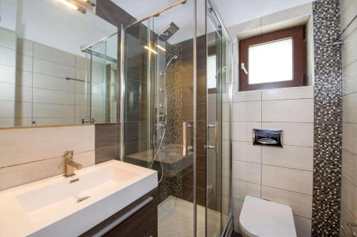 a bathroom with a sink and a glass shower at Marilia by Vintage Travel in Maleme