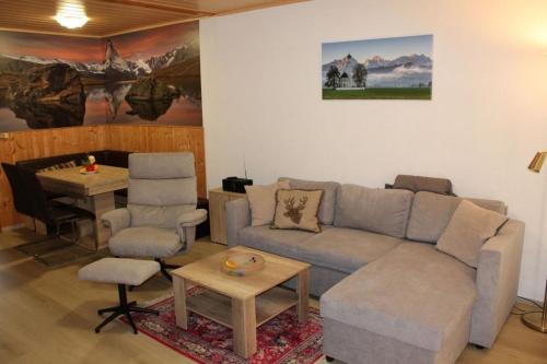 un salon avec un canapé et une table dans l'établissement Ferienhaus Nr 29, Kategorie Königscard, Feriendorf Hochbergle, Allgäu, à Bichel