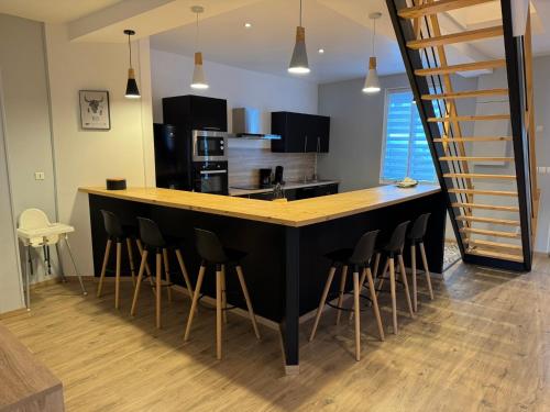 une cuisine avec un comptoir noir et des chaises de bar dans l'établissement Family Villa 29, au Tréport