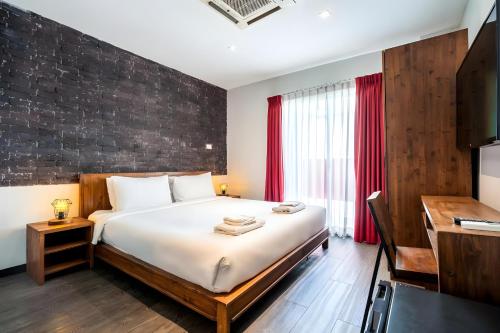 a bedroom with a large bed and a desk at Elite Hotel Asok Sukhumvit 20 in Bangkok