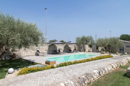 a swimming pool in a yard with a stone wall at Sammit holiday home in Michelica