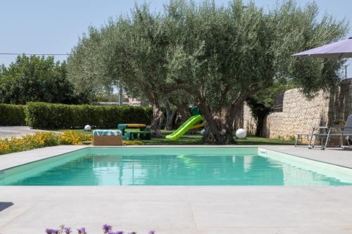 a pool with a slide in a yard with trees at Sammit holiday home in Michelica
