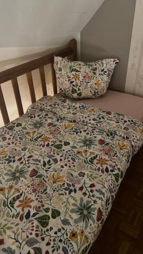 - un lit avec une couette à fleurs et 2 oreillers dans l'établissement Magnifique Duplex à 600m du Martroi, à Orléans