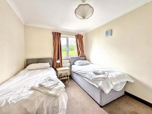 two twin beds in a room with a window at Seaside Escape-Sleeps10-Family&PetFriendly-Balcony in Porthleven